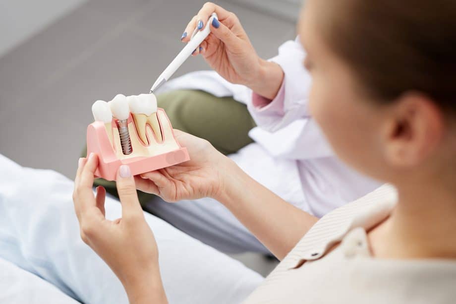 patient holding a 3D model of a dental crown